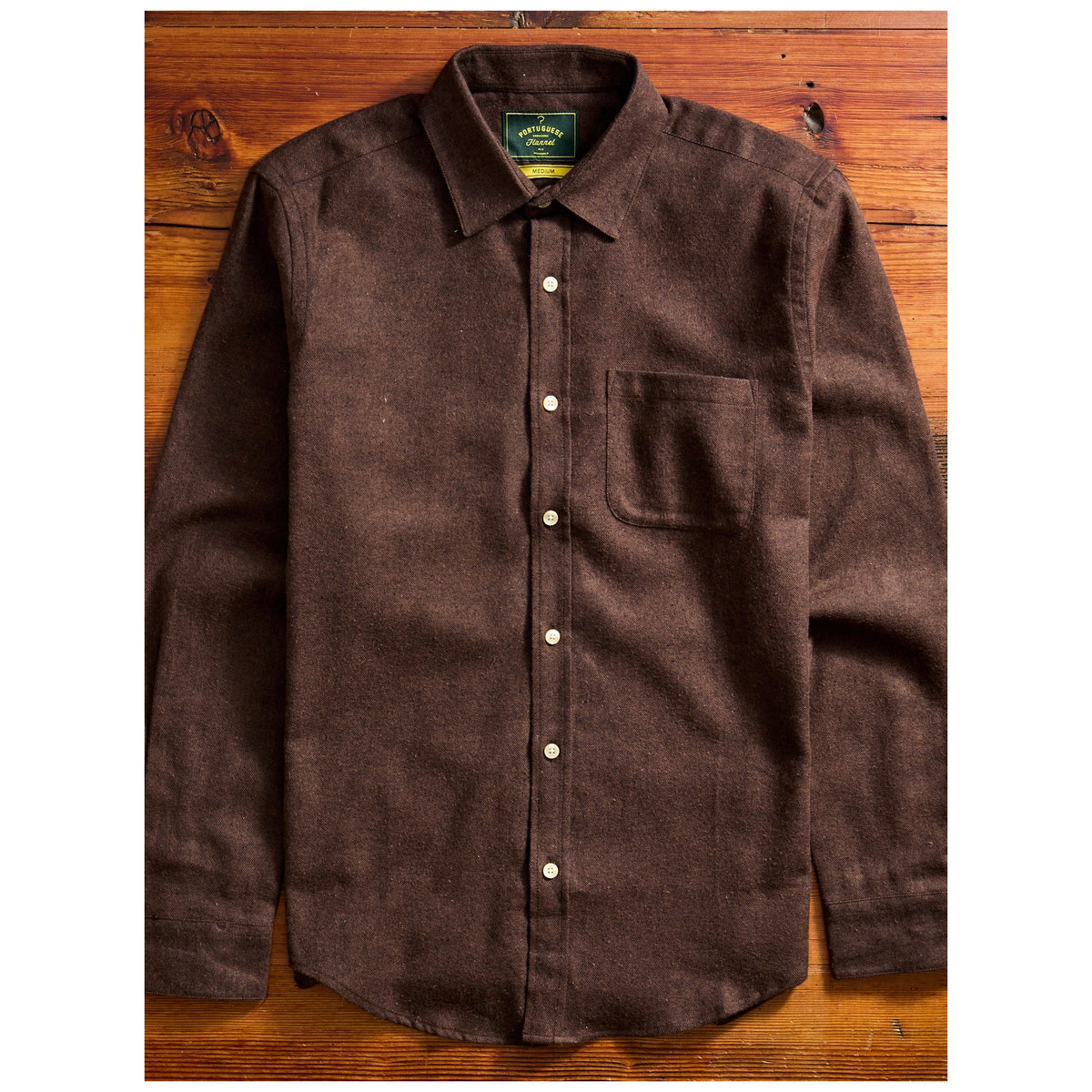 Portuguese Flannel Teca Flannel shirt in dark brown laid flat on wooden surface