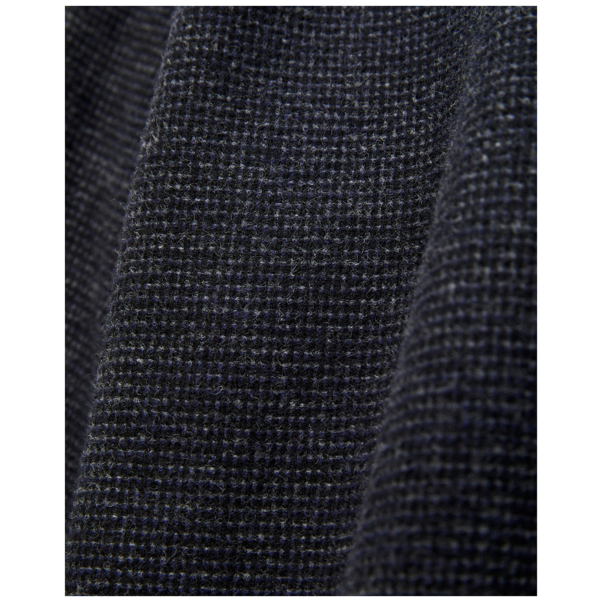 Close-up macro shot of dark navy textured wool flannel fabric weave detail