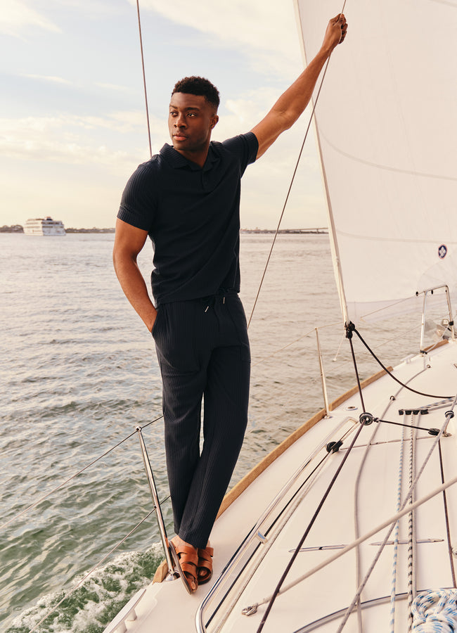 Man wearing navy seersucker pants on sailing boat lifestyle photo