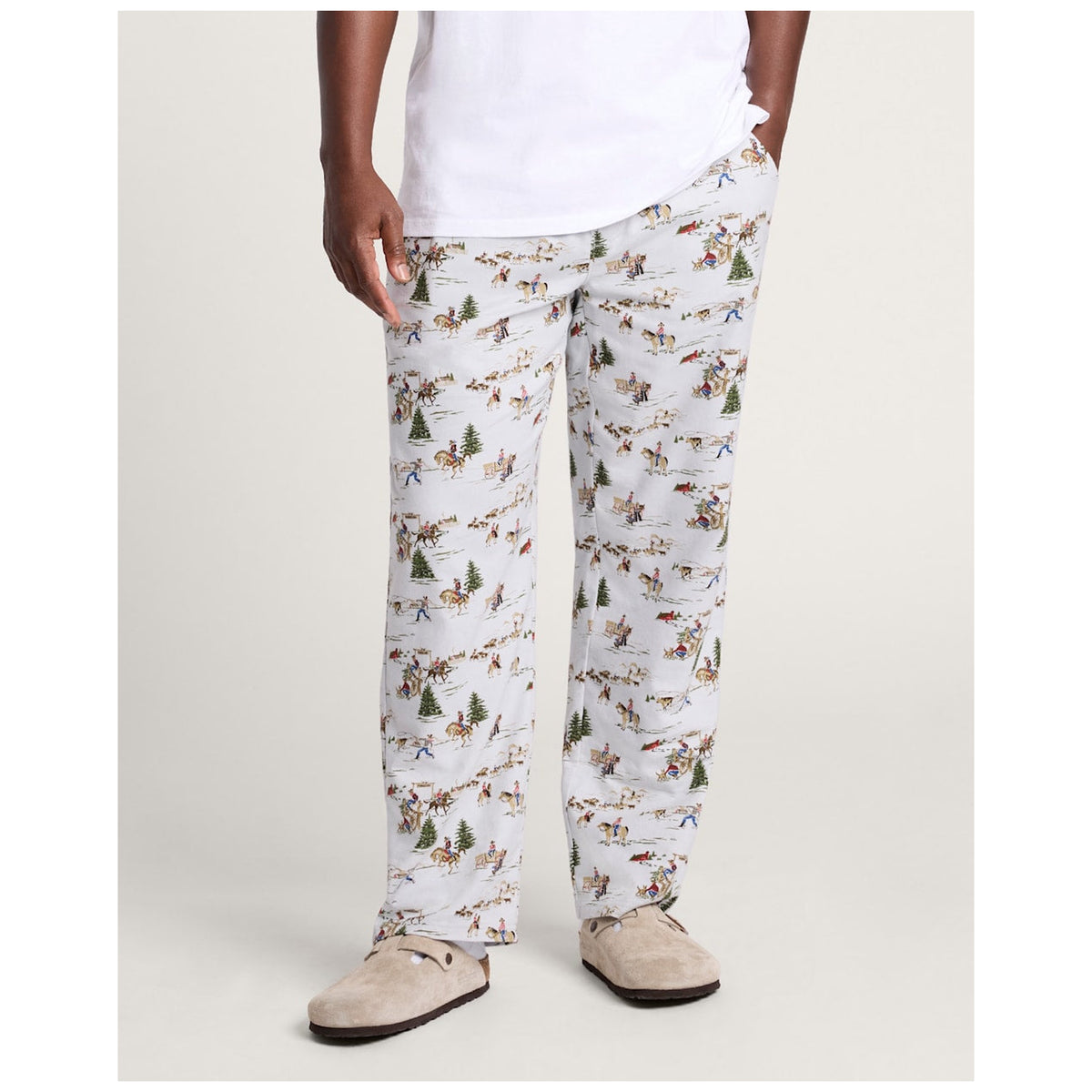 Male model wearing Pendleton Cowboy Blue pajama pants with western winter scene print and slippers