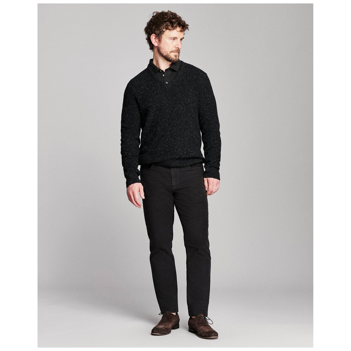 Male model wearing charcoal long-sleeve jacquard sweater polo with black pants and brown suede oxfords