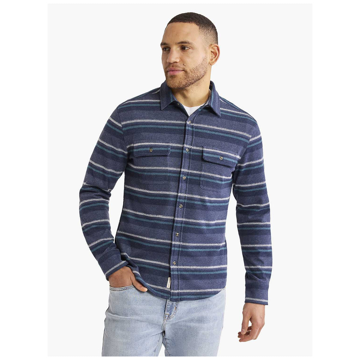 Male model wearing navy striped flannel button-up shirt with chest pockets and light jeans