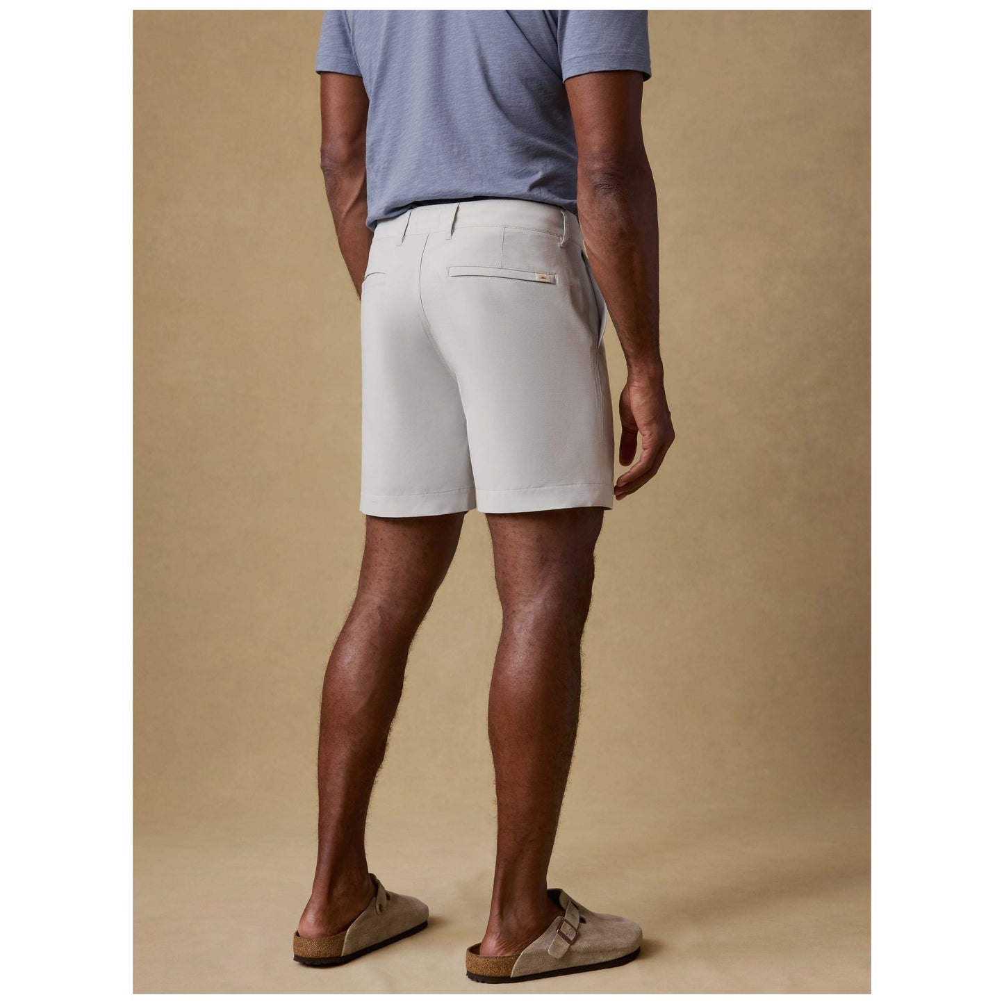 Man wearing stone colored All Day Shorts from behind showing fit and styling