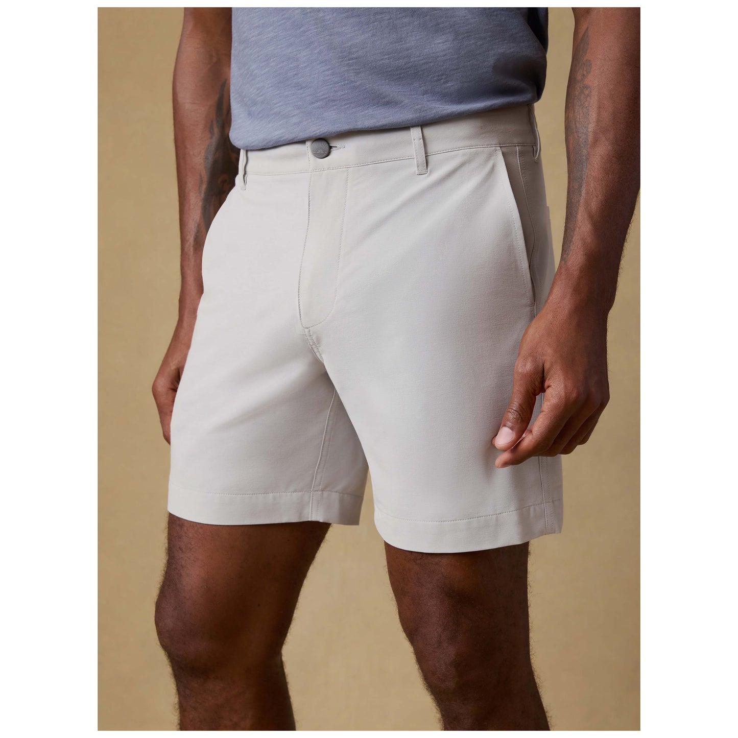 Model wearing stone colored All Day Shorts with 7 inch inseam and gray t-shirt