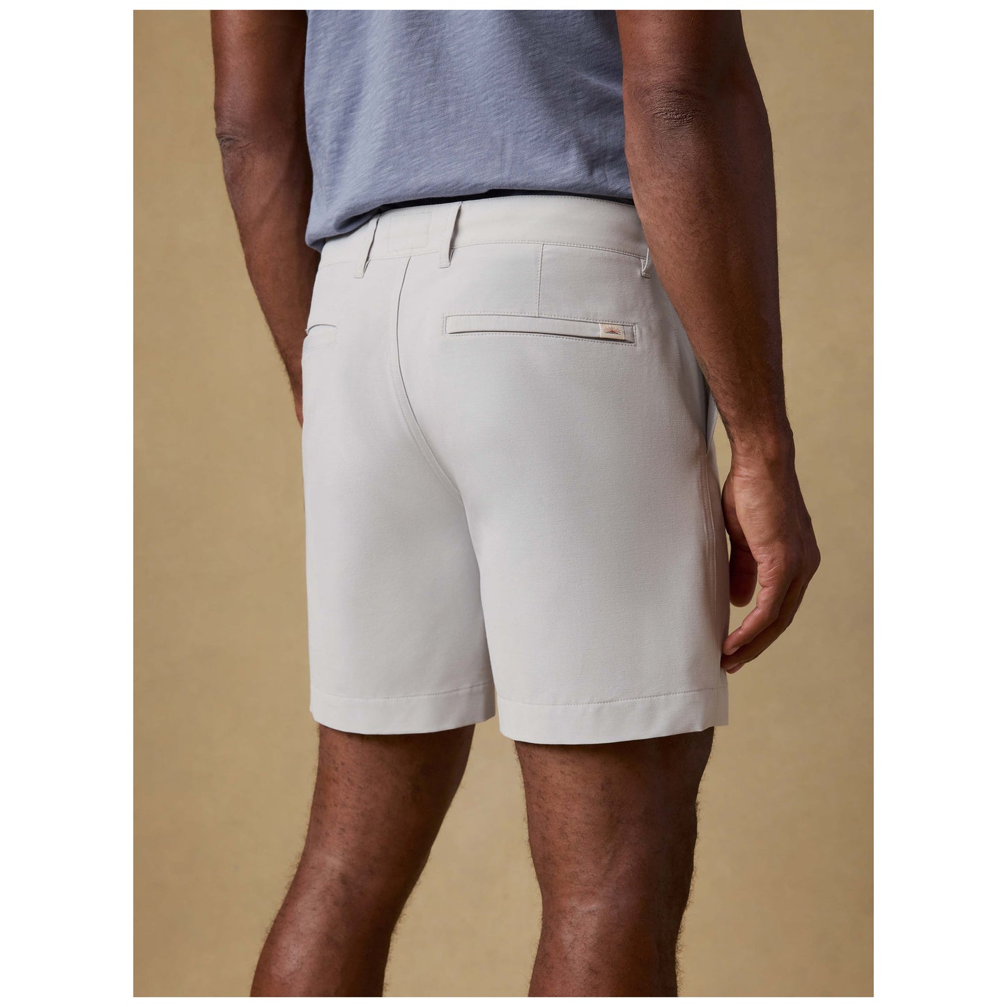 Model wearing stone colored All Day Shorts with 7 inch inseam and blue t-shirt