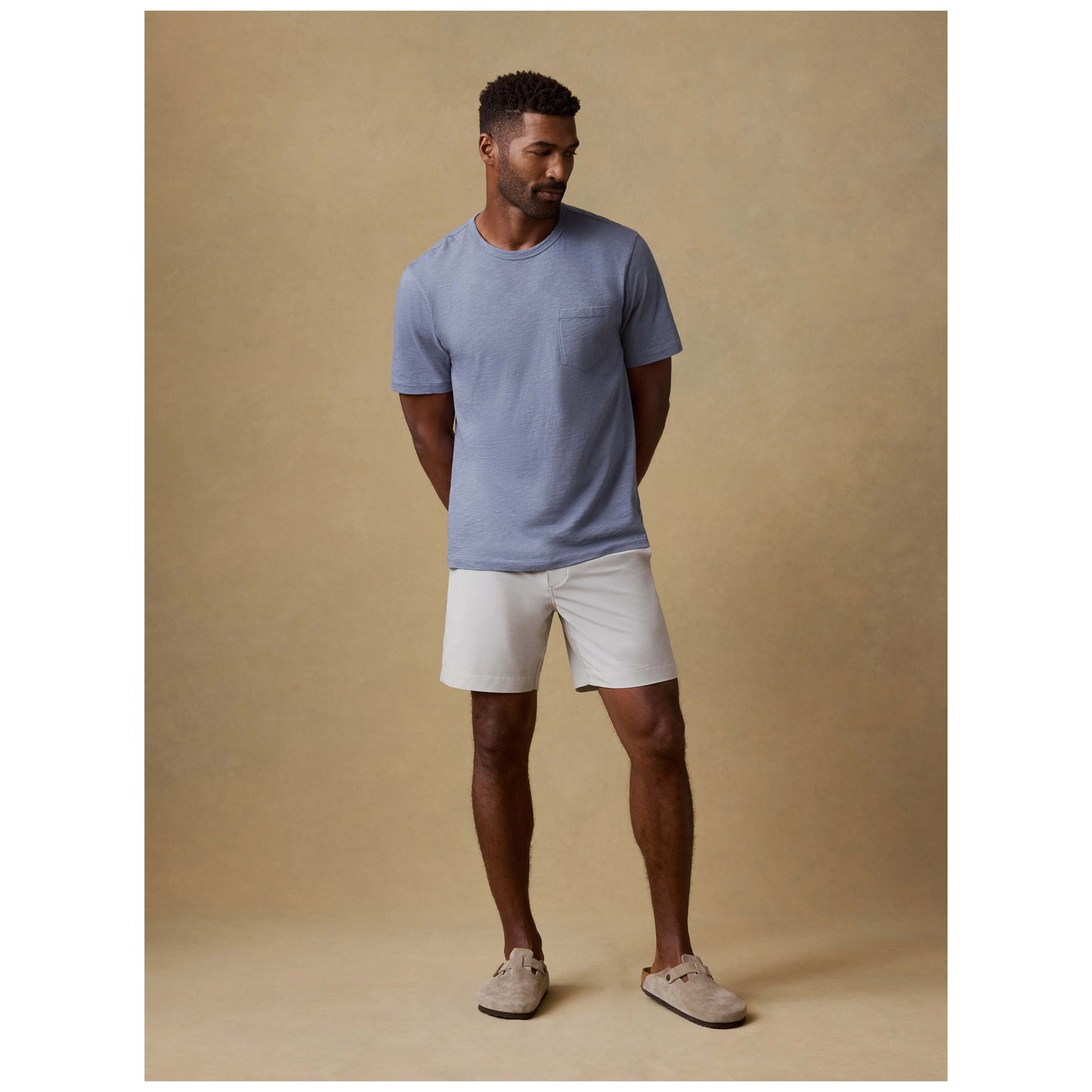 Man wearing stone colored chino shorts with blue t-shirt and loafers