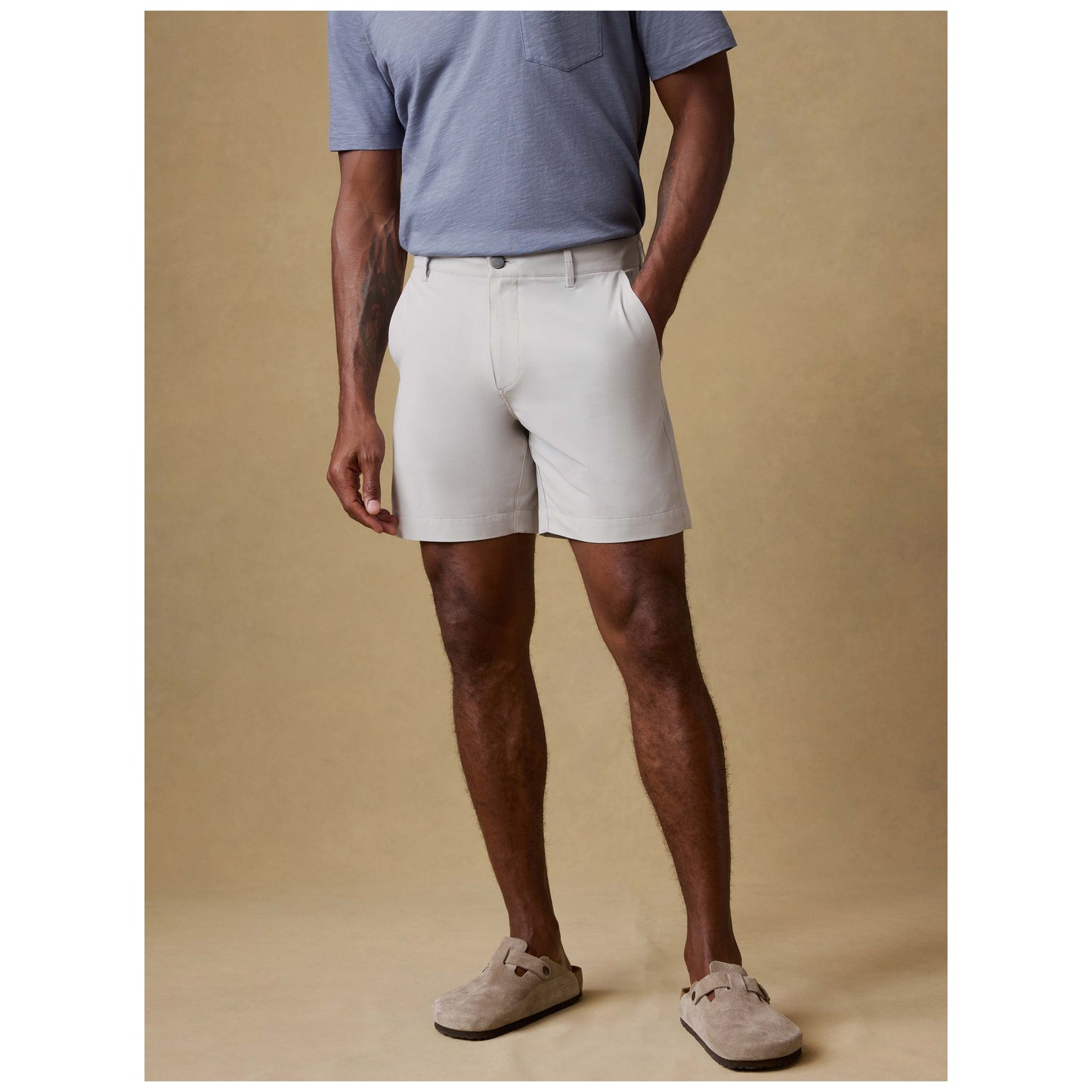 Model wearing stone colored All Day Shorts with blue pocket tee