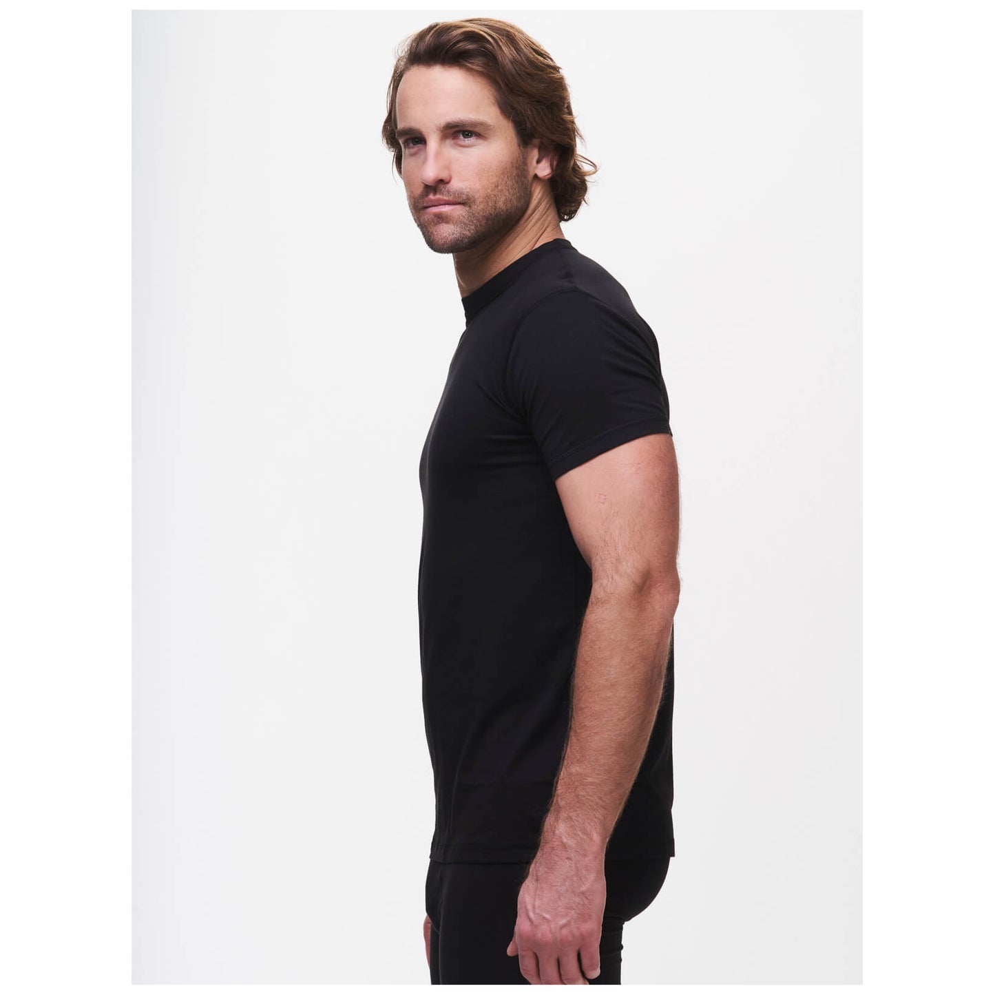 Man wearing black crew neck undershirt in professional studio setting