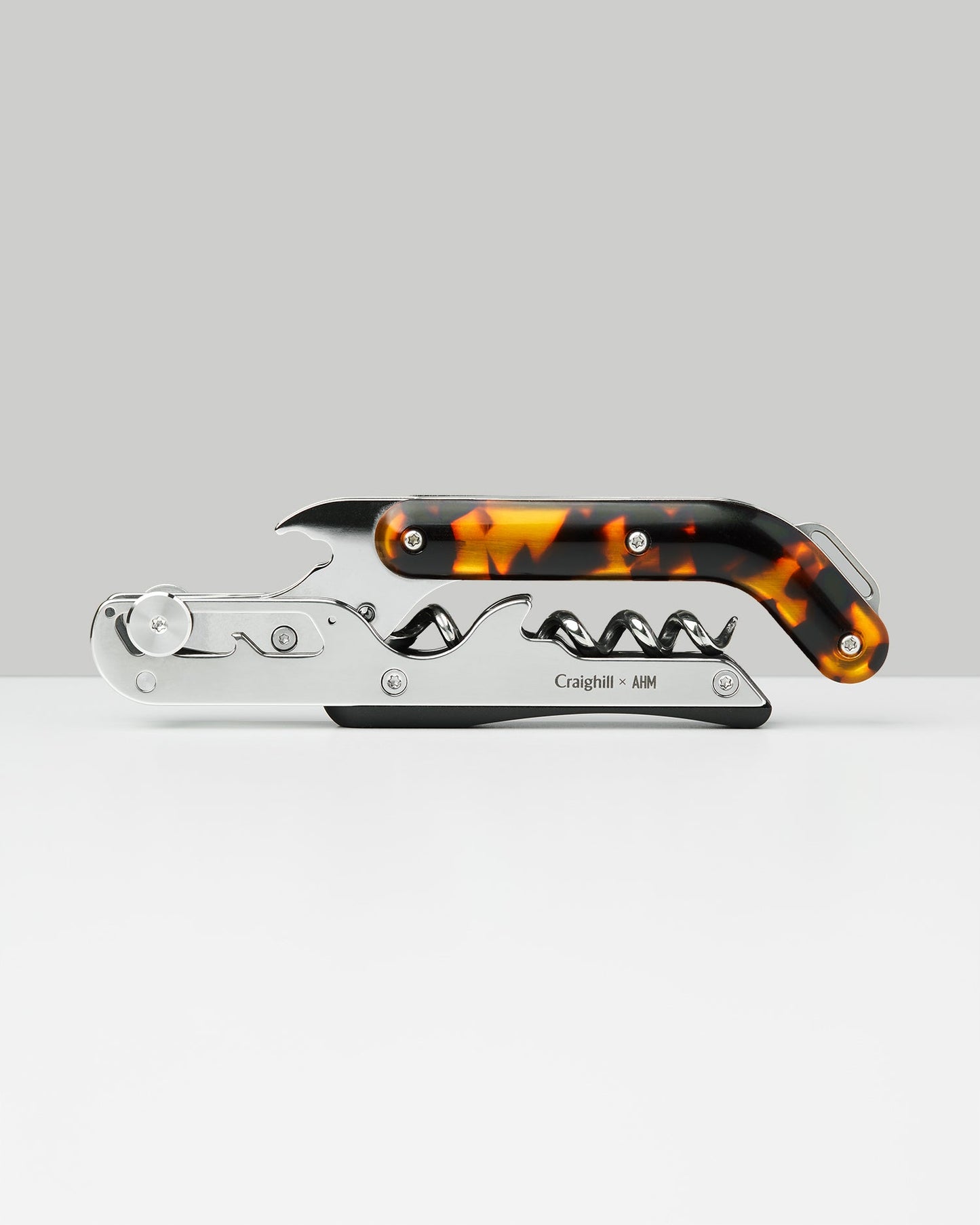 Craighill stainless steel wine opener with tortoiseshell resin handle on gray background